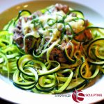 A tantalizing plate of Beef Zucchini Noodles with Pesto, showcasing spiralized zucchini and succulent beef slices, topped with a vibrant green pesto sauce.